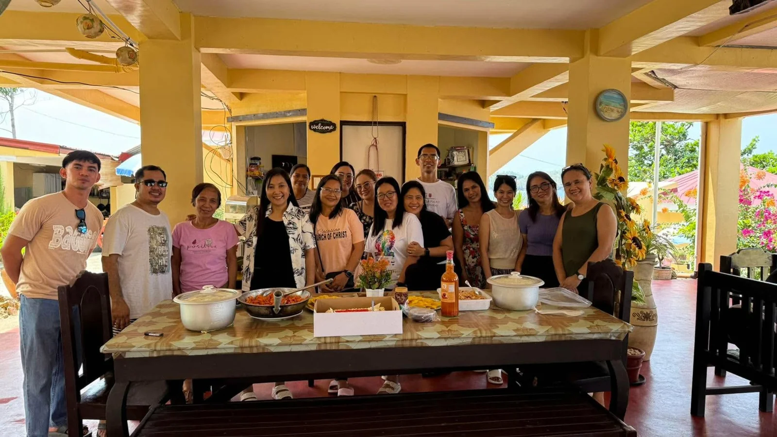 A group gathered behind a table set with food