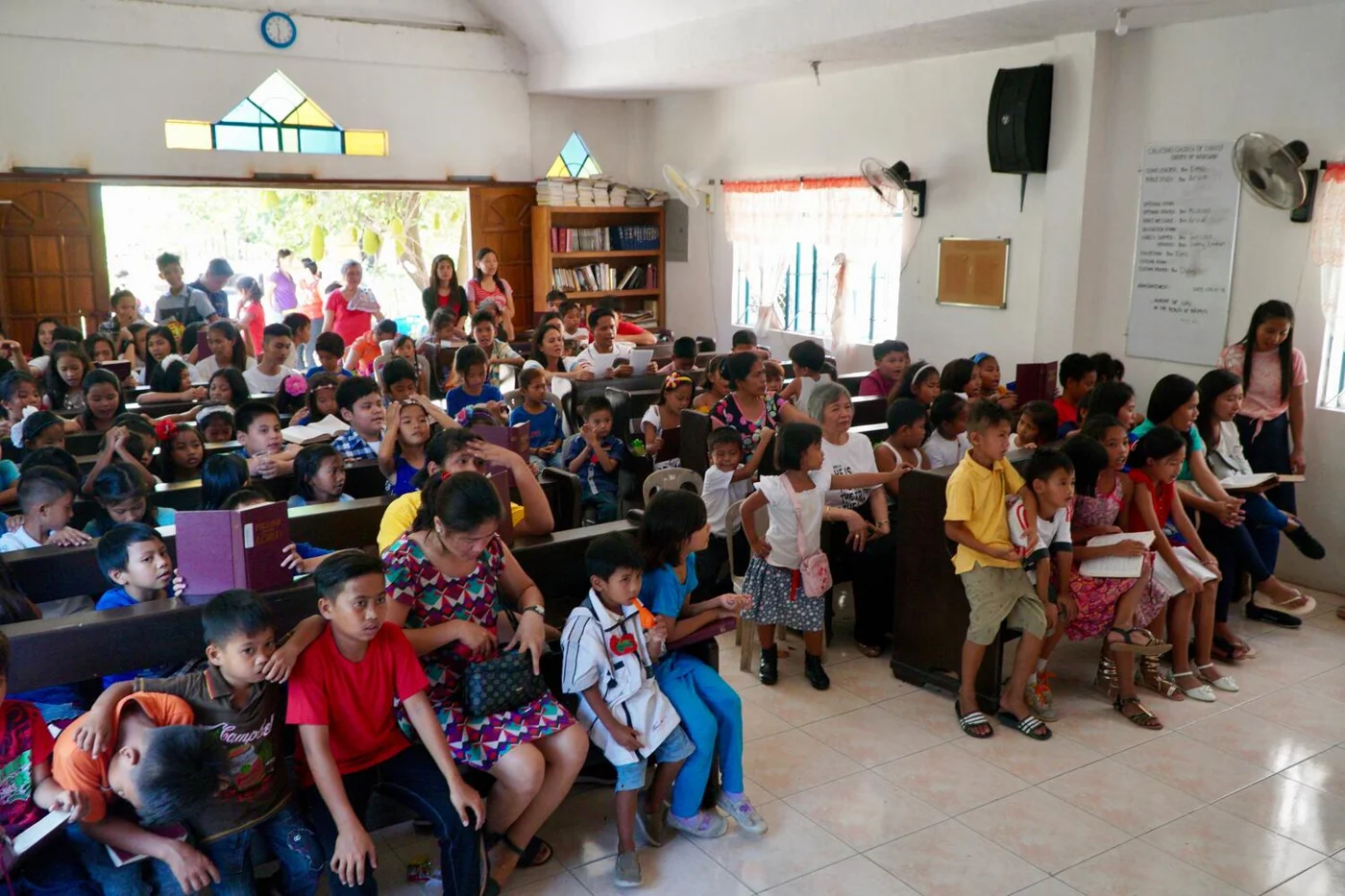 Children and adults gathered in a church hall